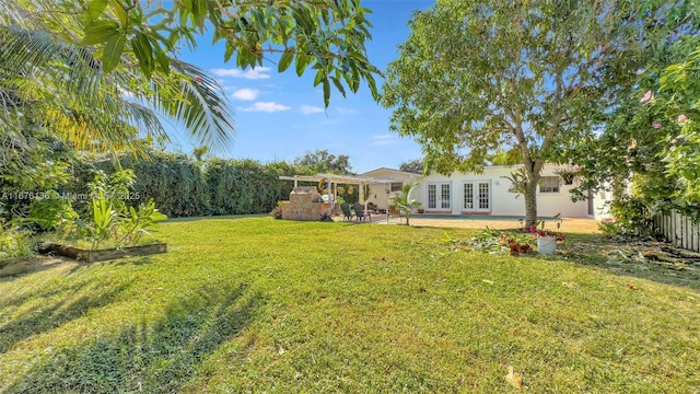 view of yard featuring a patio and french doors