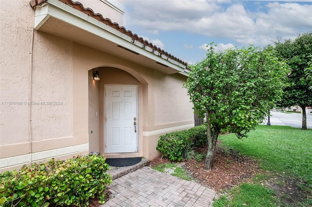 entrance to property featuring a yard