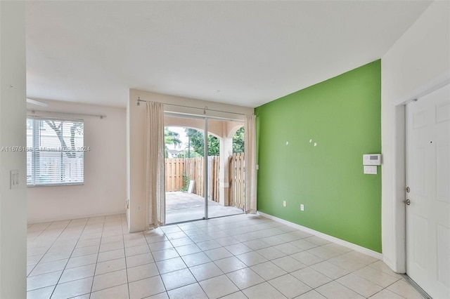 unfurnished room with plenty of natural light and light tile patterned floors