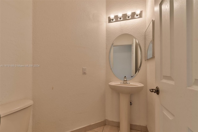 bathroom with toilet and tile patterned flooring