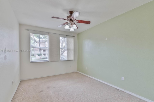 empty room featuring ceiling fan and light colored carpet