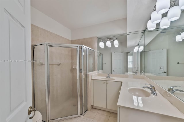 bathroom featuring vanity, a shower with shower door, toilet, and tile patterned flooring