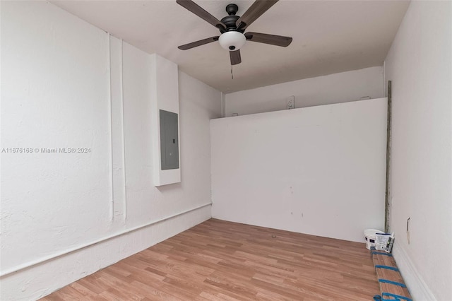 empty room with light hardwood / wood-style flooring, electric panel, and ceiling fan