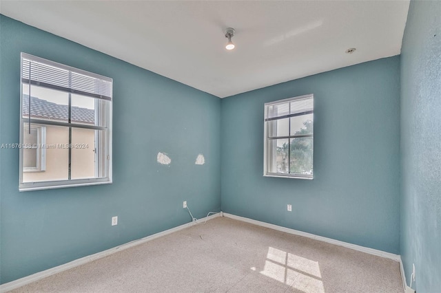 carpeted spare room with a healthy amount of sunlight