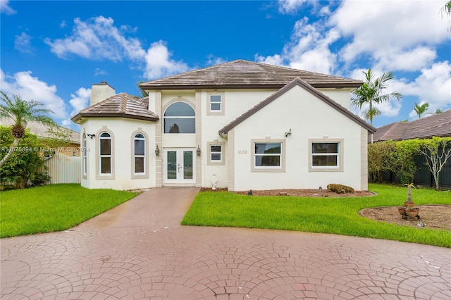 rear view of house featuring a yard and french doors