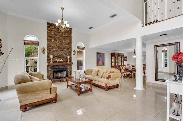 tiled living room featuring ornate columns, a healthy amount of sunlight, crown molding, and a stone fireplace