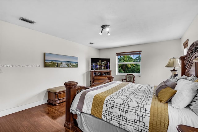 bedroom with dark hardwood / wood-style flooring