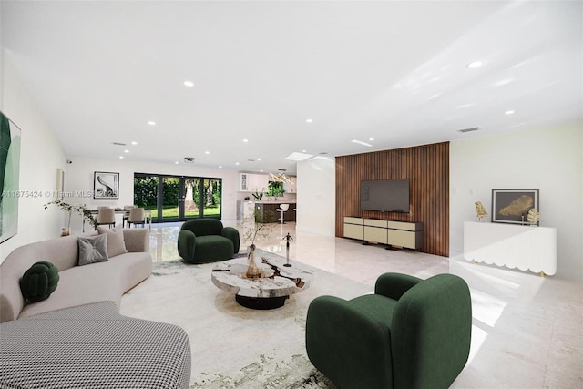 living area with marble finish floor, visible vents, and recessed lighting