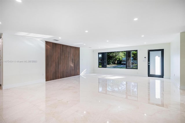 unfurnished living room featuring marble finish floor, visible vents, baseboards, and recessed lighting