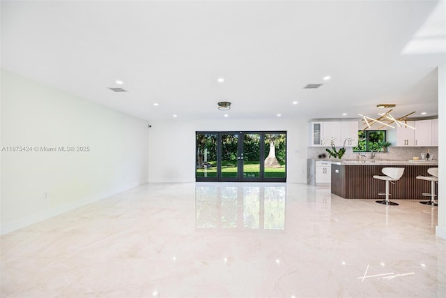 living room featuring recessed lighting, marble finish floor, visible vents, and french doors