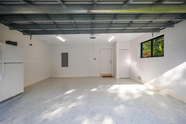 garage with freestanding refrigerator, electric panel, and visible vents