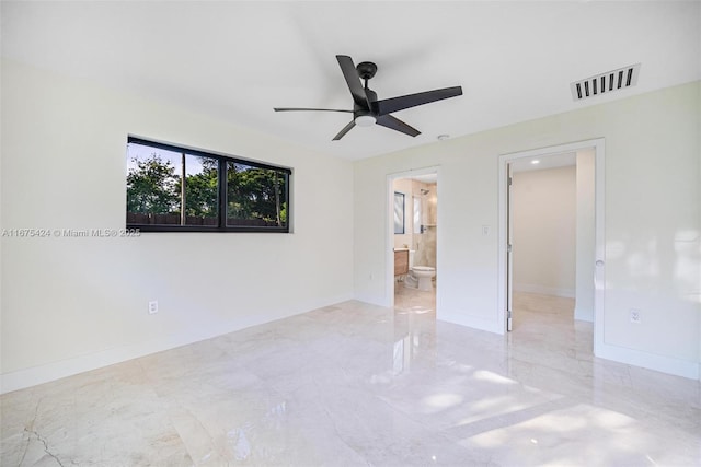 unfurnished room with ceiling fan, marble finish floor, visible vents, and baseboards