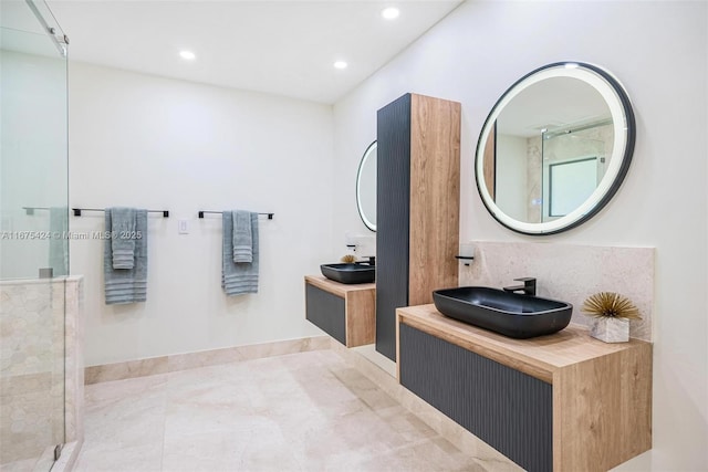 bathroom featuring recessed lighting, two vanities, a stall shower, a sink, and tile patterned flooring