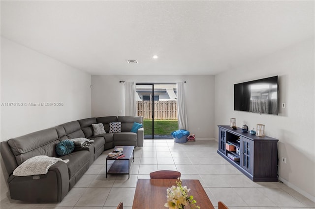 living room featuring light tile patterned flooring, visible vents, and baseboards