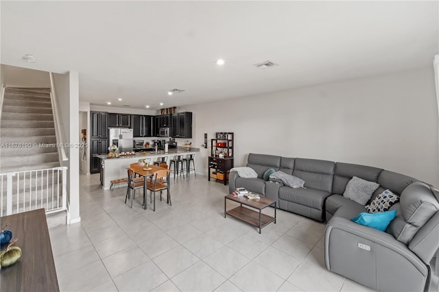 living room with recessed lighting, visible vents, stairway, and light tile patterned floors