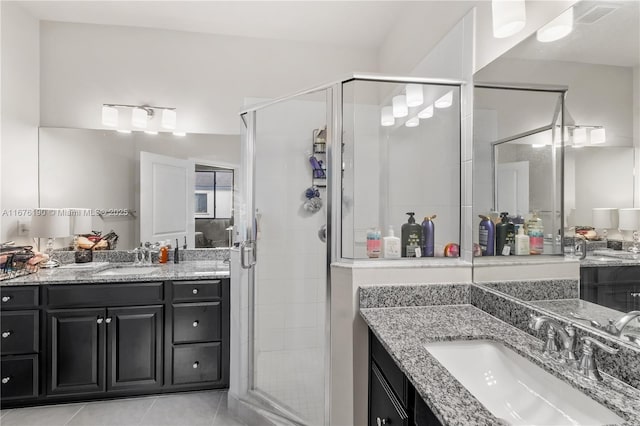 full bathroom featuring a stall shower, a sink, and tile patterned floors