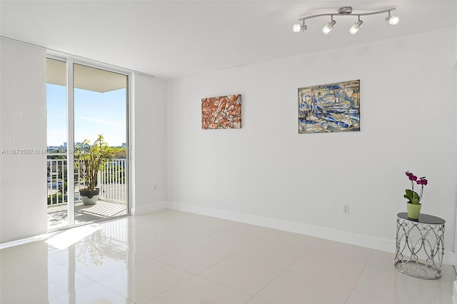 empty room with light tile patterned flooring, floor to ceiling windows, and a healthy amount of sunlight