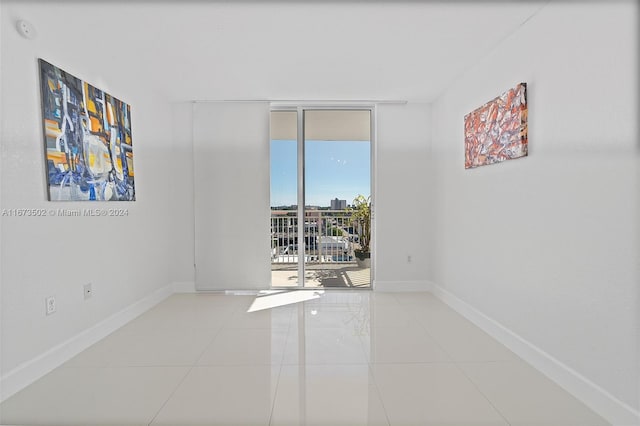 tiled spare room featuring a wall of windows