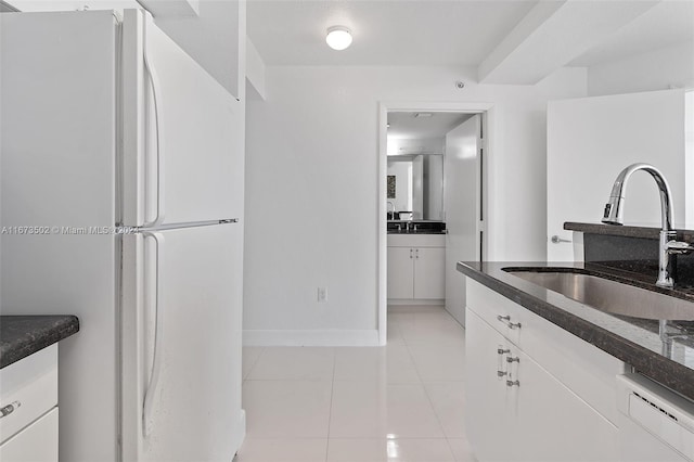 kitchen with white cabinets, white fridge, dishwashing machine, and sink