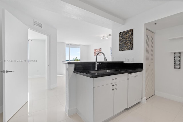 kitchen with light tile patterned flooring, sink, kitchen peninsula, white cabinets, and dishwasher