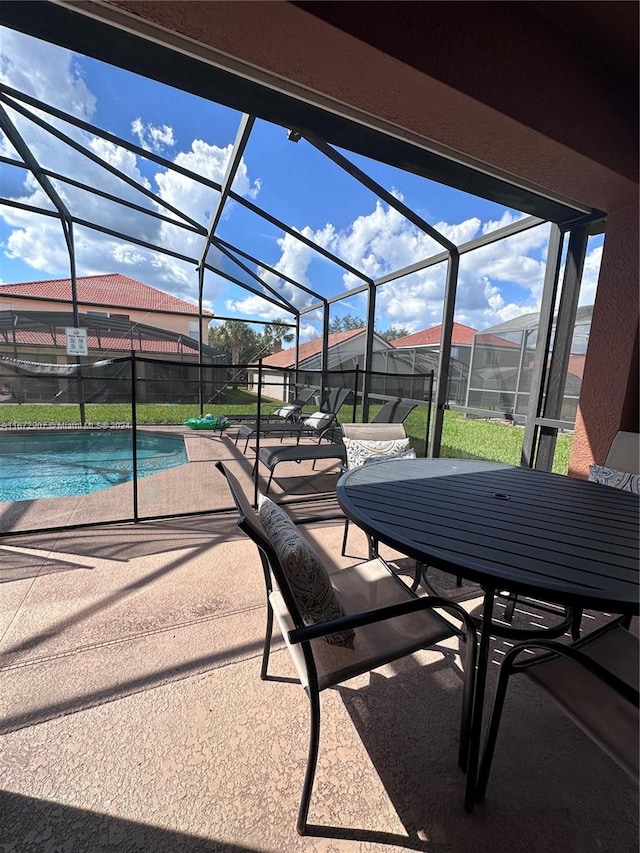 view of patio / terrace featuring glass enclosure and a fenced in pool