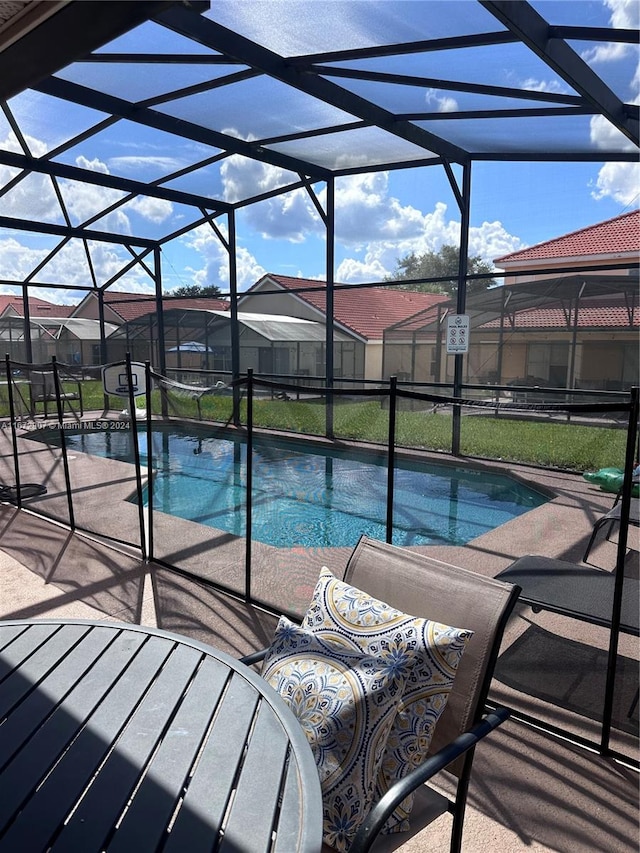 view of pool featuring a patio and glass enclosure