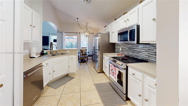 kitchen featuring appliances with stainless steel finishes, lofted ceiling, and white cabinets