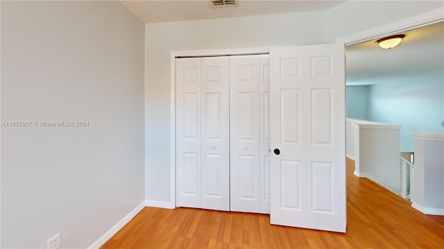 unfurnished bedroom featuring hardwood / wood-style flooring and a closet