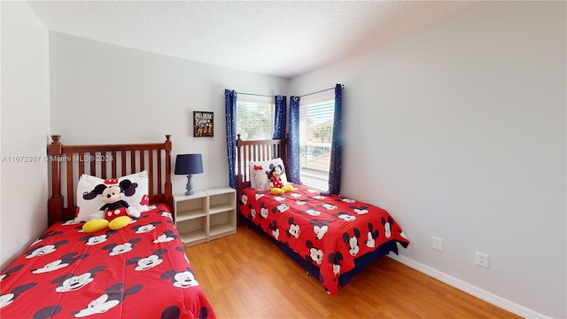 bedroom featuring hardwood / wood-style flooring and a textured ceiling