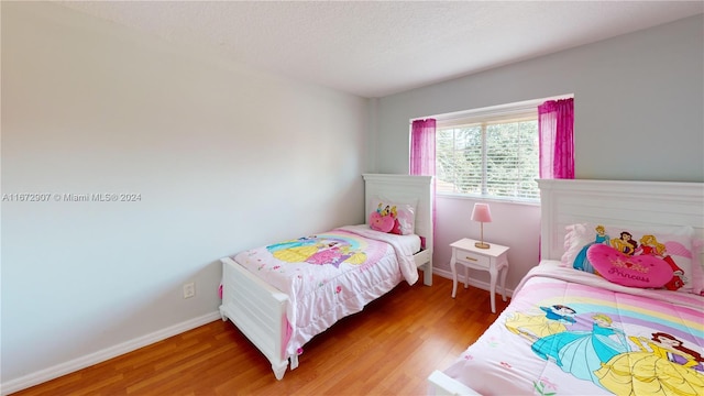 bedroom with hardwood / wood-style flooring and a textured ceiling