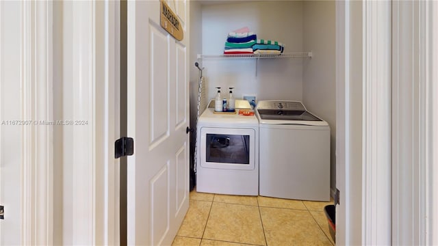 laundry room with light tile patterned flooring and washing machine and clothes dryer