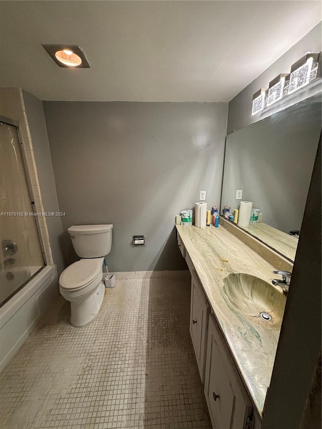 full bathroom with shower / bath combination with glass door, vanity, tile patterned flooring, and toilet