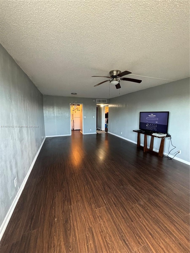 unfurnished living room with ceiling fan, dark hardwood / wood-style flooring, and a textured ceiling