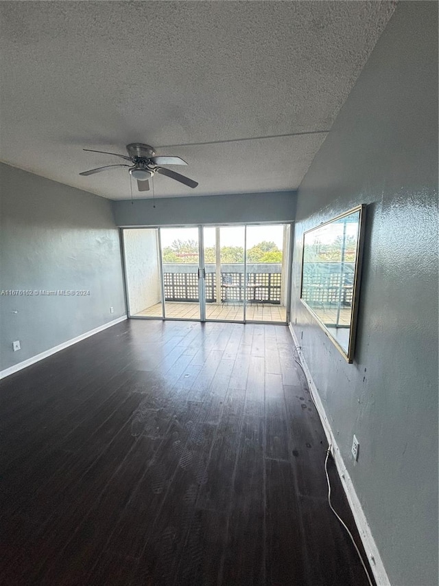 empty room with ceiling fan, a textured ceiling, and dark wood-type flooring