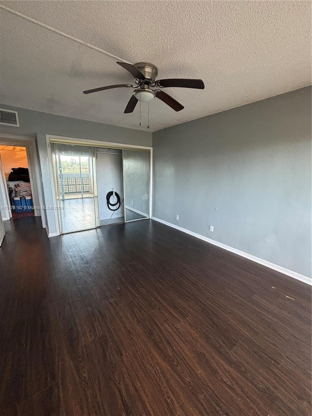 empty room featuring ceiling fan, dark hardwood / wood-style floors, and a textured ceiling