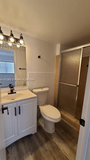 bathroom featuring an enclosed shower, hardwood / wood-style flooring, vanity, and toilet