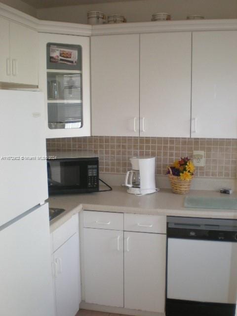 kitchen featuring white appliances, white cabinetry, and tasteful backsplash