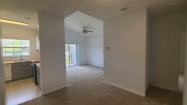 interior space featuring vaulted ceiling, ceiling fan, sink, and light colored carpet