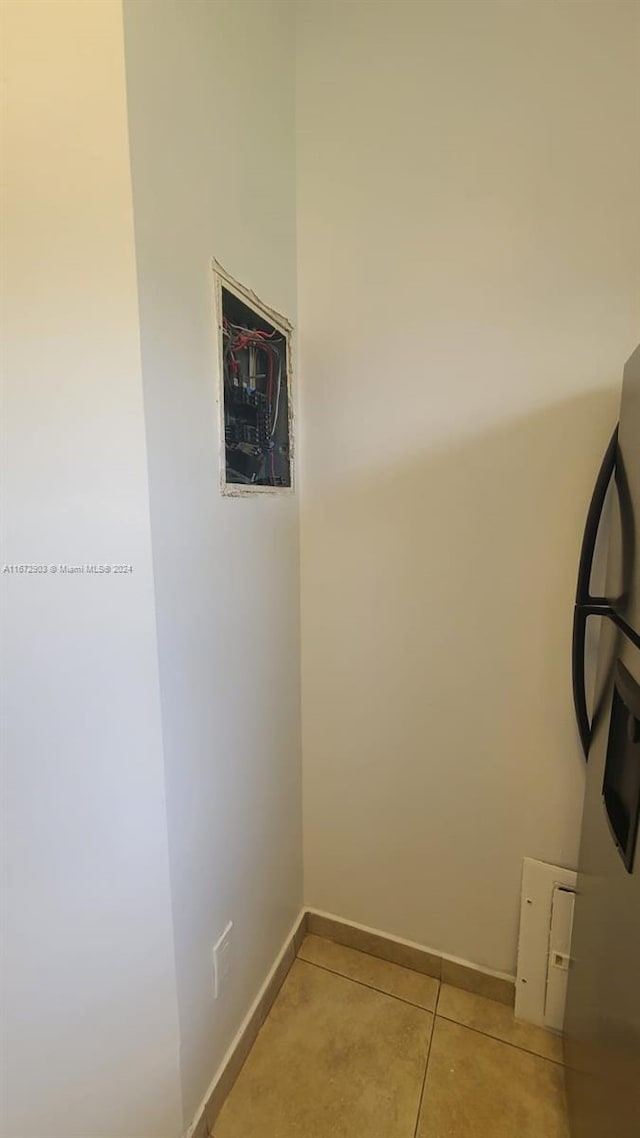 interior details with stainless steel refrigerator and tile patterned flooring