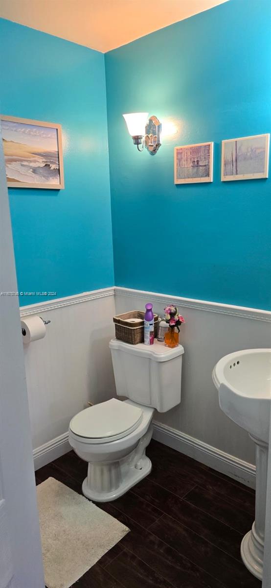 bathroom with hardwood / wood-style floors and toilet