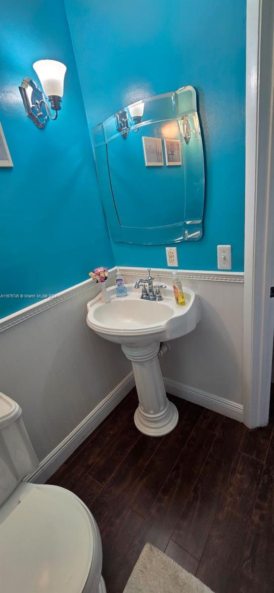 bathroom with hardwood / wood-style flooring and toilet