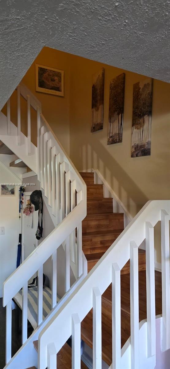 staircase with a textured ceiling