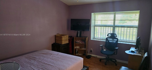 bedroom with hardwood / wood-style floors and multiple windows