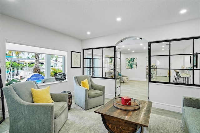 living room featuring a textured ceiling and light hardwood / wood-style floors