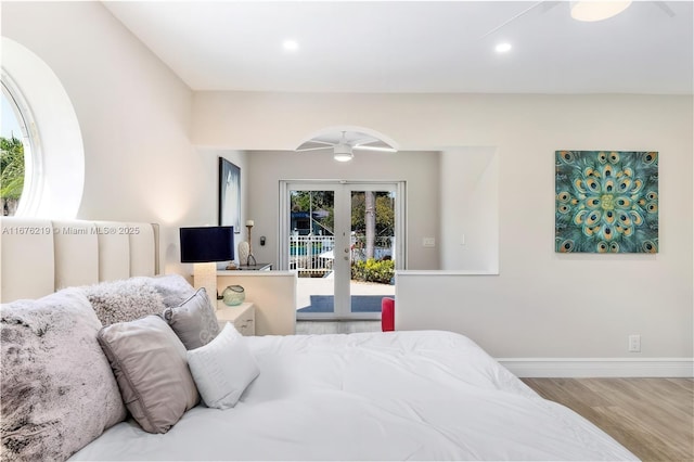 bedroom with light wood-type flooring, access to outside, ceiling fan, and french doors