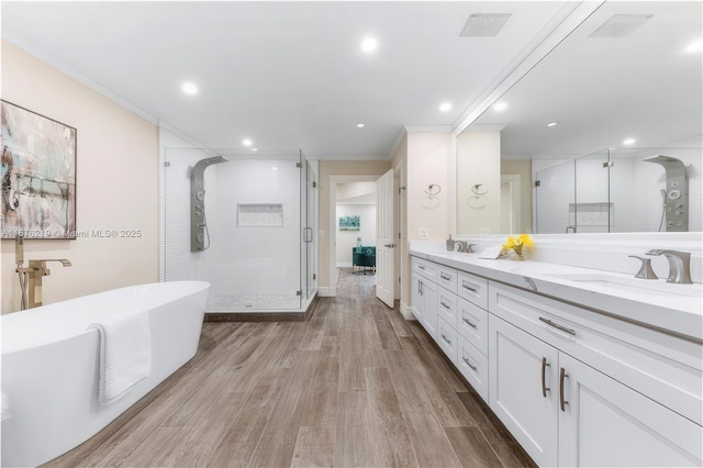 bathroom with vanity, hardwood / wood-style flooring, ornamental molding, and separate shower and tub