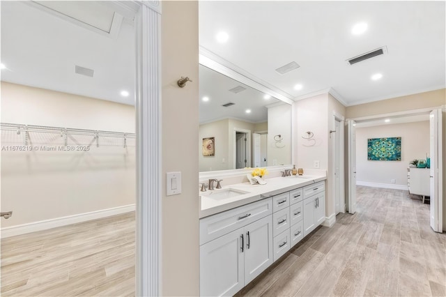 bathroom featuring hardwood / wood-style flooring, vanity, and ornamental molding