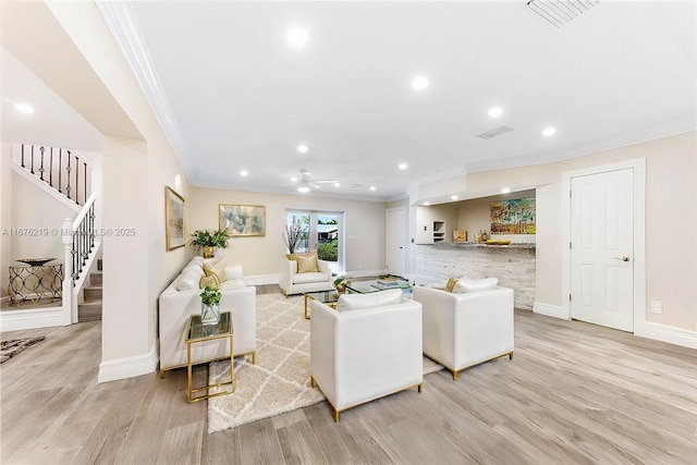 living room with crown molding and light wood-type flooring