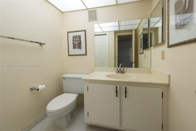 bathroom with toilet, vanity, and tile patterned floors