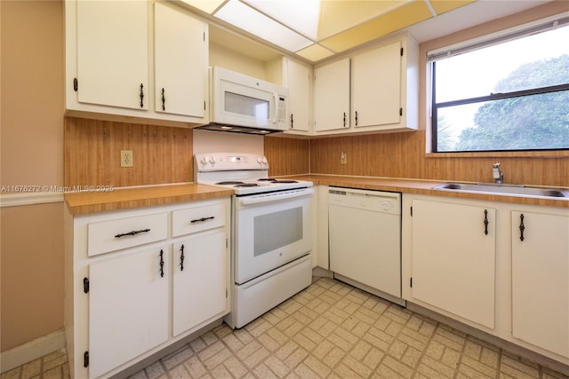 kitchen featuring white cabinetry, sink, and white appliances